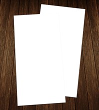 Two blank white sheets of paper on a dark wooden background, White blank flyer on wooden background