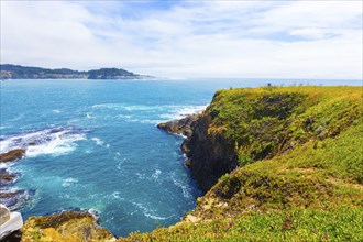 Beautiful rocky coastline and churning ocean below cliffs near Mendocino Bay on sunny day in