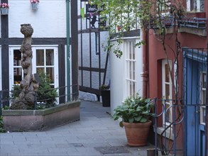 Narrow alley between half-timbered houses with flowers and colourful doors and windows, Bremen,