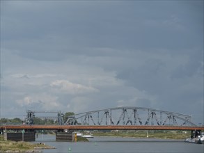 A steel bridge spanning a river under a cloudy sky, zutphen, Netherlands