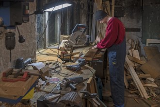 Young man working in his workshop in the evening, Mecklenburg-Vorpommern, Germany, Europe