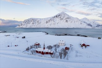 Flakstad church in snowy landscape, mountain and fjord, Lofoten, Norway, Europe