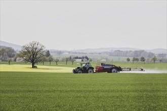 A tractor with a trailed field sprayer drives in a field in Vierkirchen, 12/04/2024