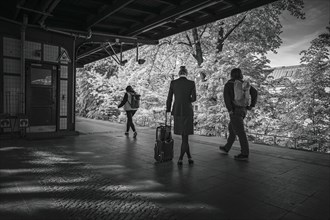 Symbolic photo on the subject of working woman. A woman in a business outfit stands with a suitcase