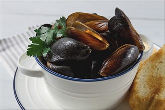 Fresh, Boiled mussels, Black Sea, with white bread, on a white wooden table, no people