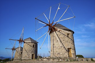 Two old windmills under a clear blue sky and a natural landscape, windmills, on a ridge, above