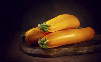 Yellow zucchini, fresh, raw, on a wooden chopping board, no people