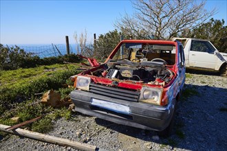 An abandoned, red car without bonnet overlooking the sea, wrecked vehicle, Crete, Greek Islands,