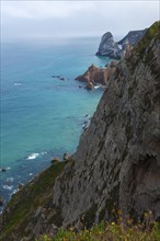 View from a cliff onto the turquoise blue sea and rocky coast, Cape Cabo da Roca, westernmost point