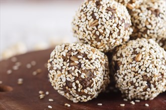 Energy balls cakes with almonds, sesame, cashew, walnuts, dates and germinated wheat on wooden