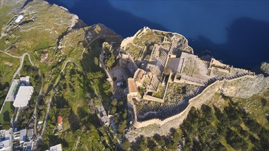 Drone shot, Acropolis of Lindos, late afternoon light, view from above of a historic fortress on