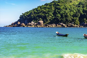 Rustic wooden fishing canoes on the sea waters of Ilhabela Island on the northern coast of Sao