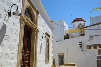 A quiet street with white buildings and colourful accents under a bright blue sky, Chora, Old Town,