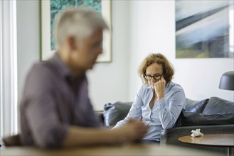 Symbolic photo on the subject of problems in a partnership. An older woman and an older man sitting