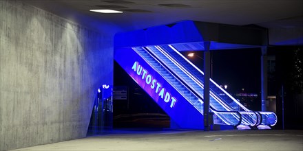 Illuminated escalator to the Autostadt under the phæno building at night, Wolfsburg, Lower Saxony,