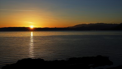 Gulf of Kissamos, sunrise over the sea, the light reflects on the calm water and mountains can be