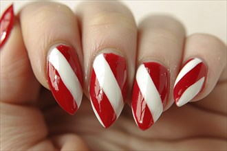 Close up of woman's fingernails with red and white colored nail polish with seasonal Christmas