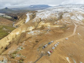 Steaming hot springs and colourful rhyolite mountains, parking lot, aerial view, Hveradalir