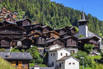 Old wooden houses in the historic centre of Grimentz, with the church of Saint Theodule, Val