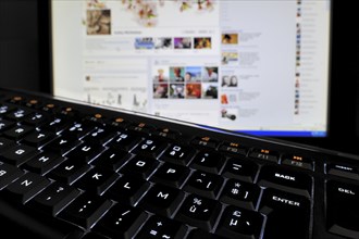 Black computer keyboard with illuminated backlit white keys