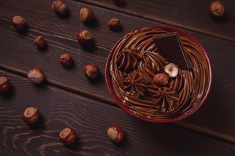 Chocolate nut paste, mousse, pasta, in a cup, on a wooden table, top view, selective focus, no