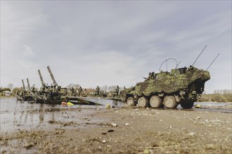 A Pandur II tank navigates the Bundeswehr's Amphibie M3 floating high-speed bridge in the Elbe as