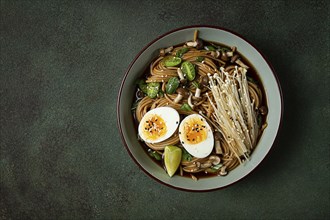 Soba, buckwheat noodles, with enoki mushrooms, shimeji and boiled egg, top view, homemade, no