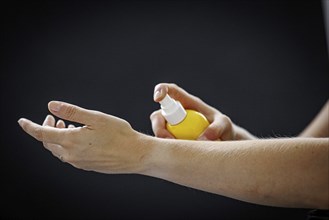 A person sprays a liquid on their arm in Berlin, 09/08/2024