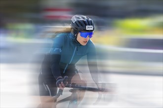 Close-up of a cyclist in a race with a blurred background that conveys speed and intensity