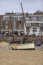 A sailing boat at low tide off the town of St Ives in Cornwall, United Kingdom, Europe