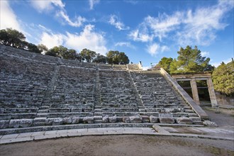 The ruins of an ancient theatre with empty stone steps and a clear blue sky, Ancient Amphitheatre,