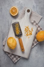 Grated lemon zest, on a cutting board, with a grater, top view, no people