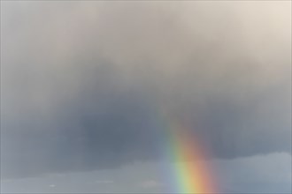 Rainbow appears in rain clouds in spring. Bas Rhin, Alsace, France, Europe