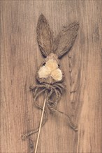 Easter bunny made of straw, on a wooden background, top view, no people