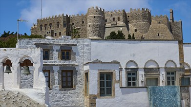 Old castle above traditional white houses with endless blue sky and bright sunshine, St John's