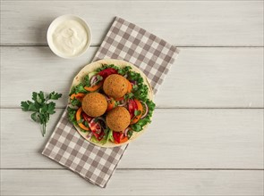 Tortillas, wrapped falafel balls, with fresh vegetables, vegetarian healthy food, on a wooden white