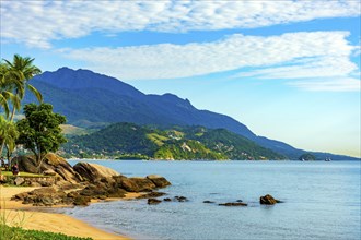 Beach with rocks and palm trees on the island of Ilhabela on the north coast of Sao Paulo with the