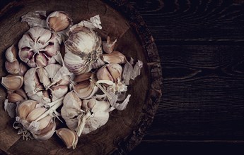 Fresh garlic, in a wooden plate, top view, close-up, no people