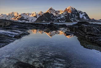 Sunrise, morning light, steep mountains by the sea, winter, Flakstadoya, Lofoten, Norway, Europe