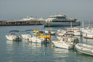 Leisure boats and incoming ferry boat in Marina Grande, Capri Island, Campania, Gulf of Naples,