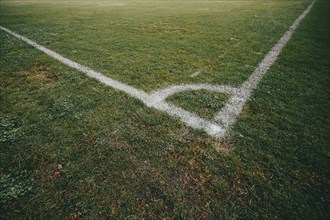 Lawn of a football pitch with marking lines, empty atmosphere, corner of the football pitch