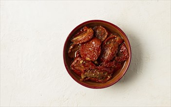 Dried tomatoes, in a bowl, top view, on a white background