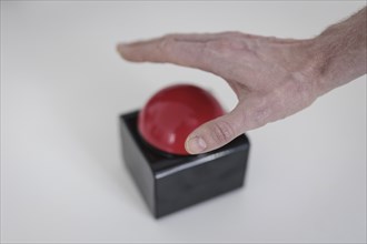 A hand presses a red buzzer button in Berlin, 27/03/2024