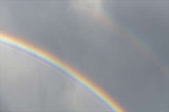 Rainbow appears in rain clouds in spring. Bas Rhin, Alsace, France, Europe