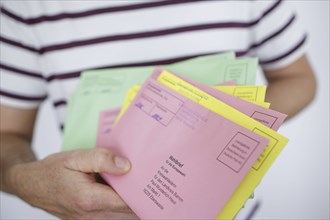 A man holds postal voting documents for the European elections, district council elections and