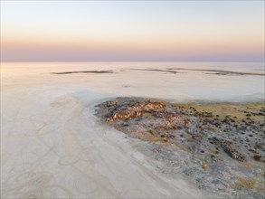 Rocky island with baobab trees in a dry salt pan, at sunset, aerial view, Kubu Island, Botswana,