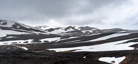 Dramatic volcanic landscape with mountains and snow, at Höskuldsskáli hut in Hrafntinnusker,