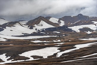 Dramatic volcanic landscape with mountains and snow, at Höskuldsskáli hut in Hrafntinnusker,