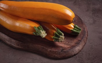 Yellow zucchini, fresh, raw, on a wooden chopping board, no people