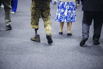 Ukraine Recovery Conference URC in Berlin. A Ukrainian soldier with a prosthesis walks through an